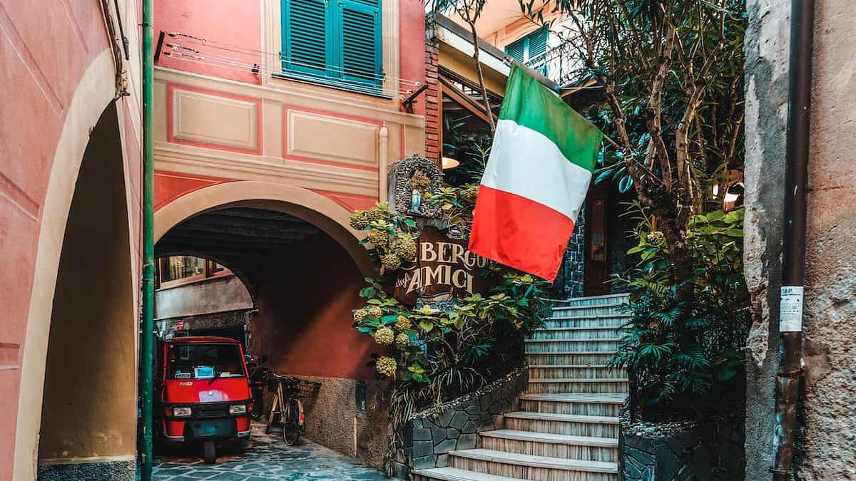 rød auto-rickshaw under en buet gangbro i en af regionerne i Italien