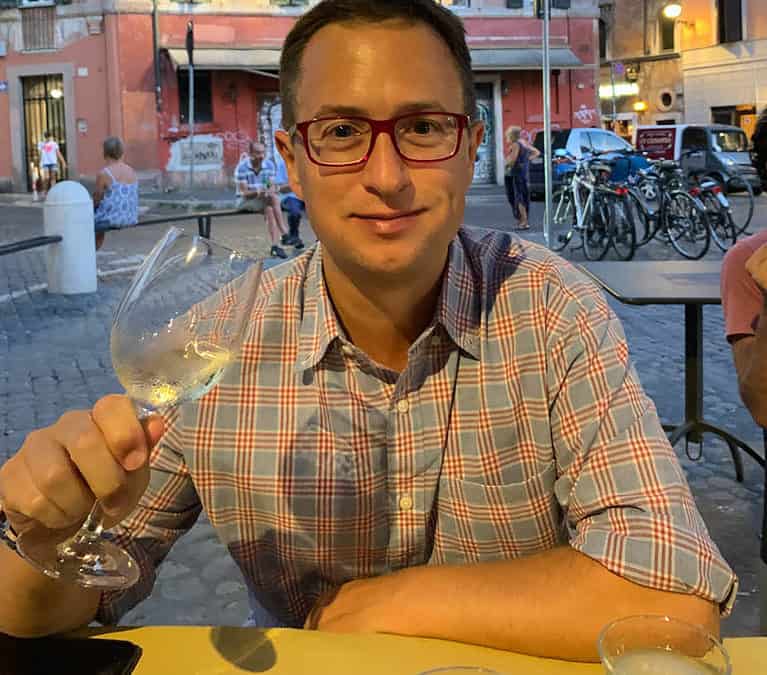 Rick drinking a glass of wine, happy he's over the drinking age in italy