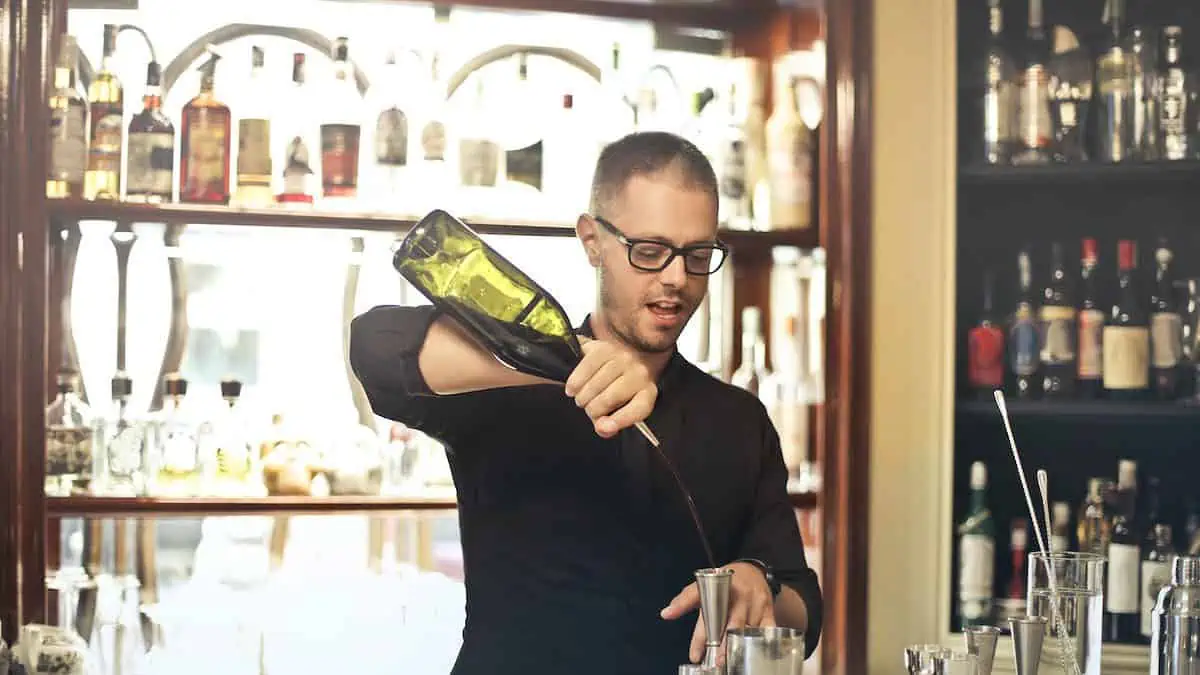 an italian bartender makes a drink