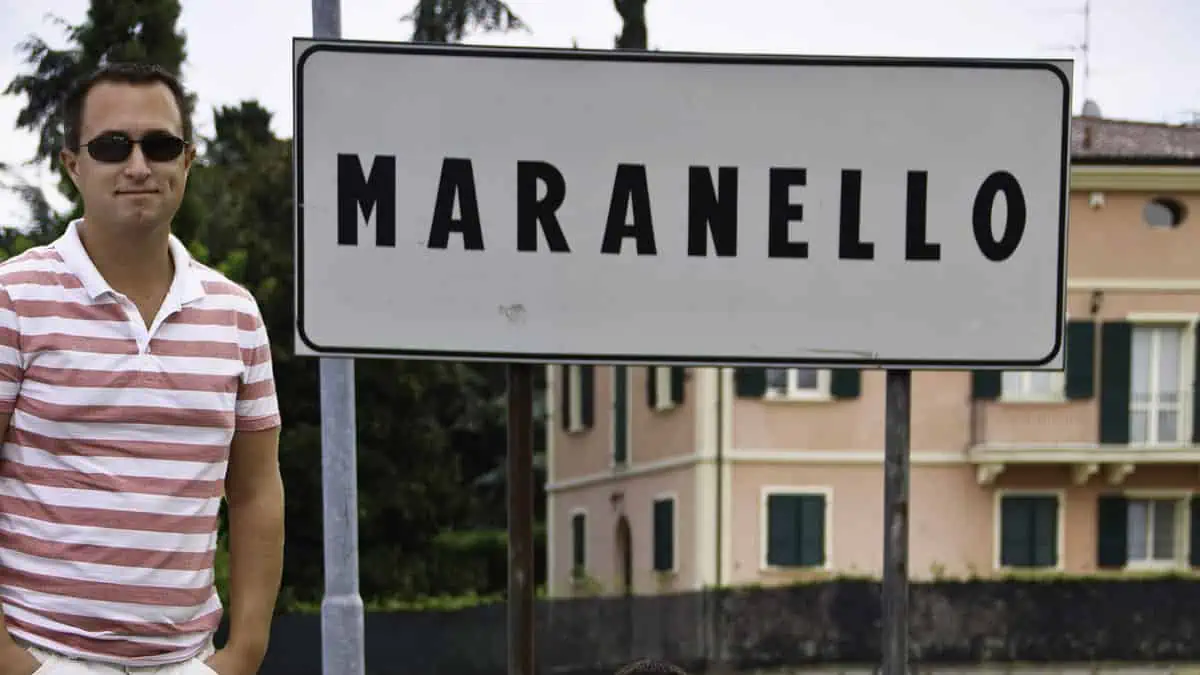 Rick devant l'enseigne Maranello à Modène, en Italie, alors qu'il se rend à l'essai d'une Ferrari.