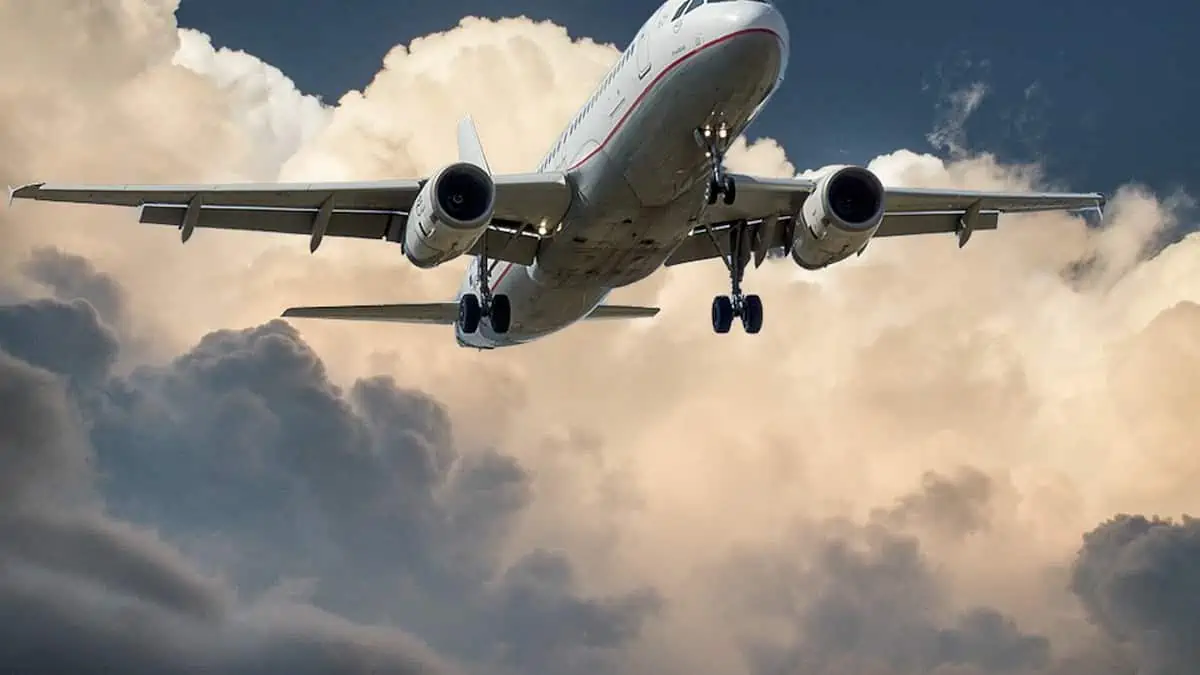 雲の横の白と赤の飛行機 ローアングル写真